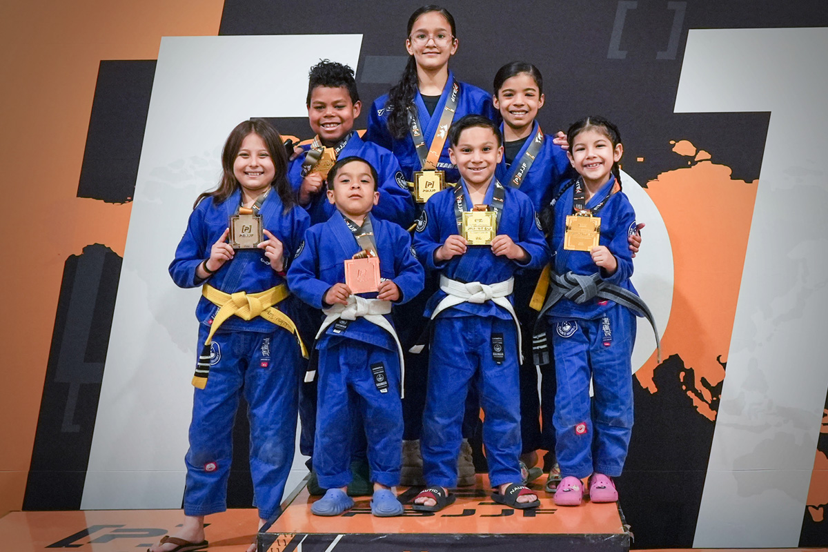 Children in the kids martial arts program proudly displaying their BJJ competition medals.